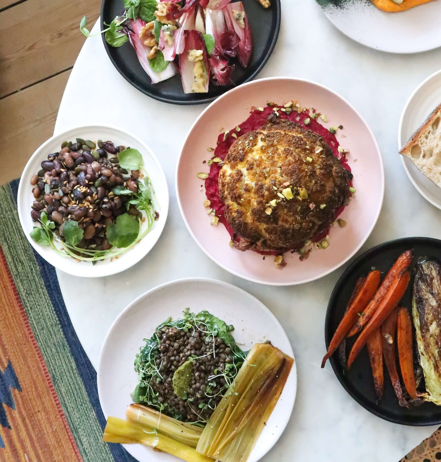 Variety of high-protein vegan ingredients like lentils, quinoa, tofu, and nuts arranged on marble surface